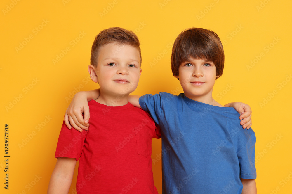 Portrait of cute brothers on orange background Portrait of cute brothers on orange background