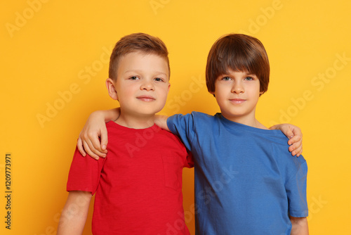 Portrait of cute brothers on orange background