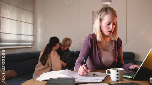 A mother works from home on her laptop in the living room, trying to focus on her tasks, while yelling at her children to calm down as they play energetically in the background.