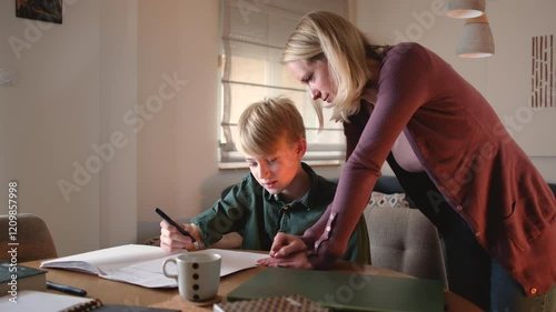 A mother and helping her son with his homework. They are using a laptop to search for information and solve tasks together.	
