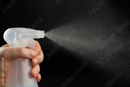 Close up of bottle in hand with spray cloud photo