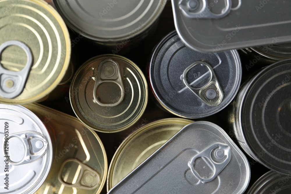 Many closed tin cans on wooden table, flat lay Many closed tin cans on wooden table, flat lay