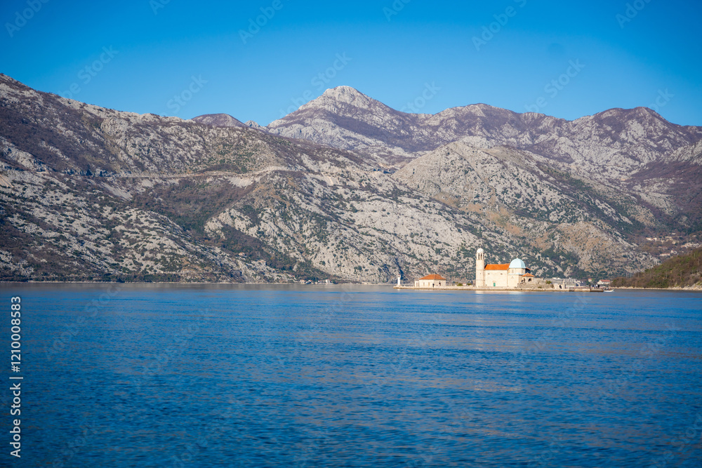 View from yacht boat of Island and Church of Our Lady of the Rocks near Perast in Montenegro. Boka Kotor bay, Europe. View from yacht boat of Island and Church of Our Lady of the Rocks near Perast in Montenegro. Boka Kotor bay, Europe.