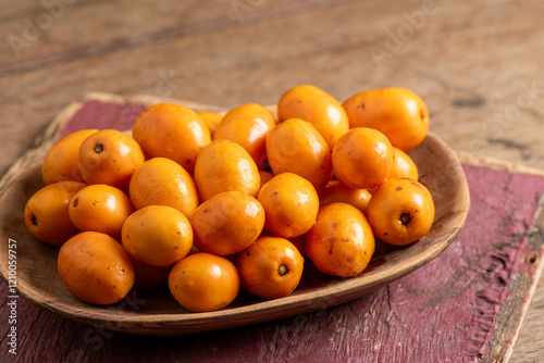 Brazilian Seriguela Fruit on a Rustic Wooden Tray photo