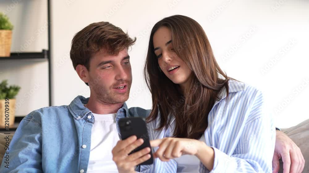 Happy millennial couple sit relax on couch in living room watching video on cellphone together, smiling young husband and wife rest on sofa at home browsing Internet using modern phone device
Happy millennial couple sit relax on couch in living room watching video on cellphone together, smiling young husband and wife rest on sofa at home browsing Internet using modern phone device