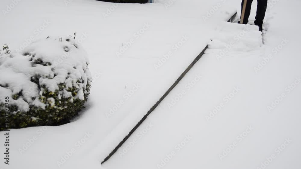 Woman cleaning her snowed back yard with plastic shovel. Winter concept. Woman cleaning her snowed back yard with plastic shovel. Winter concept.