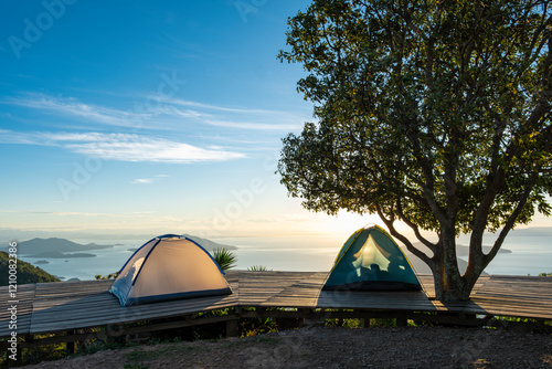 Tents at campsite at the top of Conchagua Volcano observation platform in El Salvador at early morning sunset hour. The place were borders of Honduras, Nicaragua and El Salvador meet.