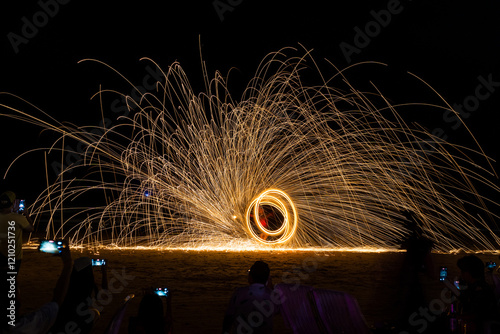 Dancer show swimg the fire of steelwool on the beach in party near bar and restaurant in Thailand photo