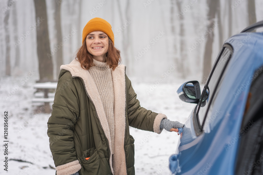 Young Caucasian woman enjoying car trip in forest in winter