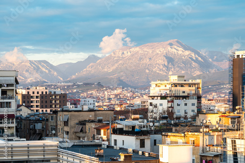 High angle view over colorful apartment blocks and mountains at dusk in the city of Tirana, Albania photo