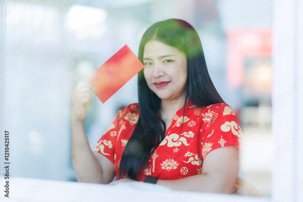 Portrait of happy asian woman relaxing wearing red cheongsam dress holding red envelopes at home in the living room indoor decoration for Chinese new year festival celebrate culture of china holiday