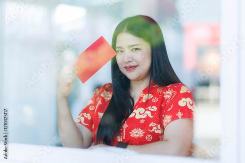 Obraz na płótnie Portrait of happy asian woman relaxing wearing red cheongsam dress holding red envelopes at home in the living room indoor decoration for Chinese new year festival celebrate culture of china holiday w salonie