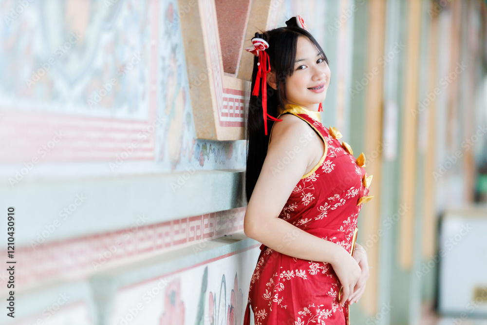 Portrait beautiful cute smiles Asian young woman wearing red cheongsam dress traditional decoration for Chinese new year festival celebrate culture of china at Chinese shrine Public places in Thailand