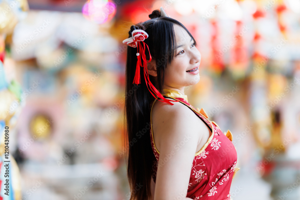 Portrait beautiful cute smiles Asian young woman wearing red cheongsam dress traditional decoration for Chinese new year festival celebrate culture of china at Chinese shrine Public places in Thailand