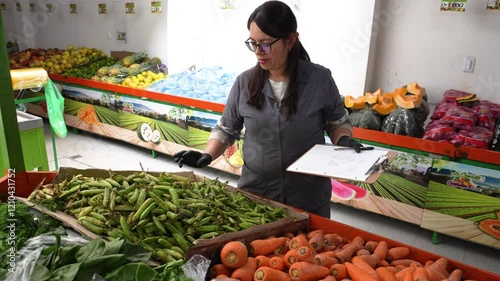 Woman supermarket employee is organizing peas in a basket