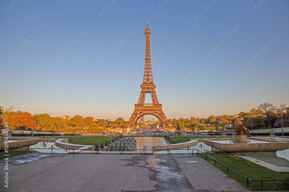Fototapeta premium Eiffel Tower in Paris glowing in the evening sunlight with fountains