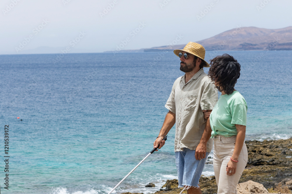 Blind man exploring nature with guidance near the sea Blind man exploring nature with guidance near the sea