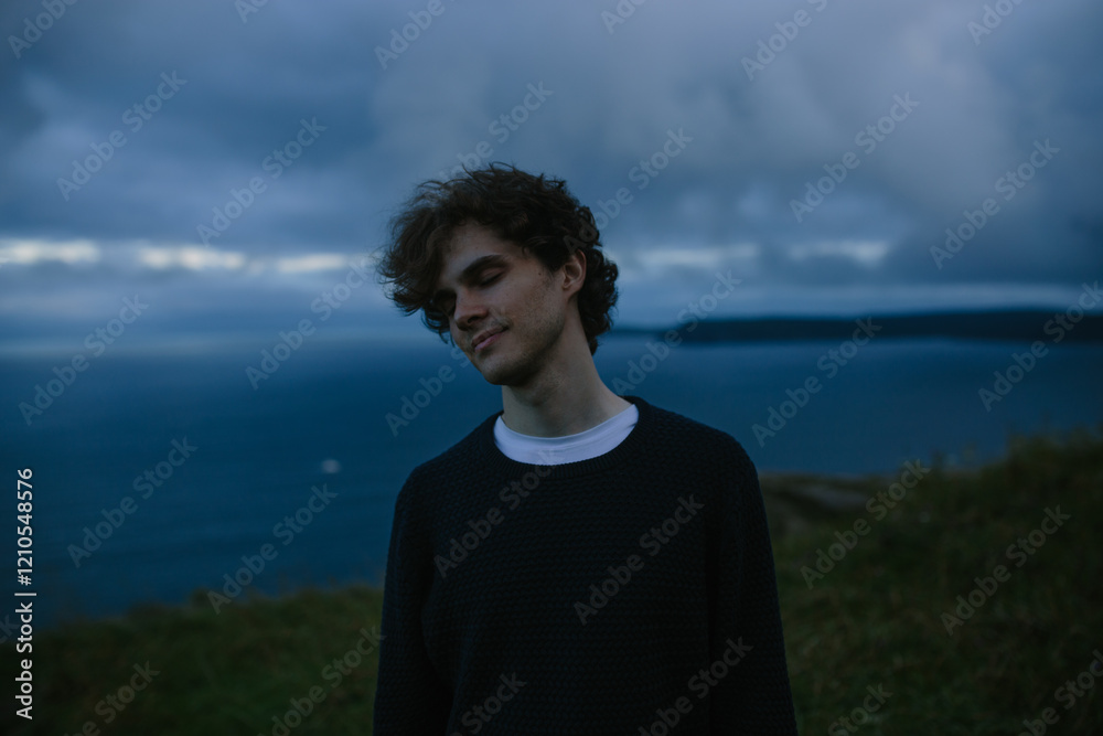 Young man contemplating by the ocean at Signal Hill in St. John's Young man contemplating by the ocean at Signal Hill in St. John's