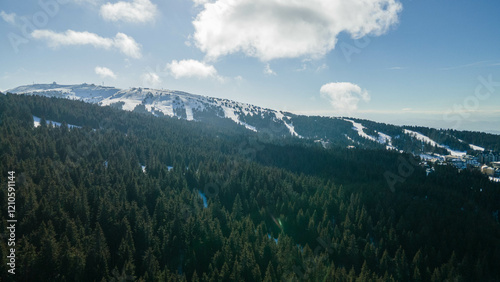 Aerial view of ski slopes in Kopaonik on a beautiful, clear day, showcasing the scenic winter landscape with perfect weather for skiing and outdoor activities.