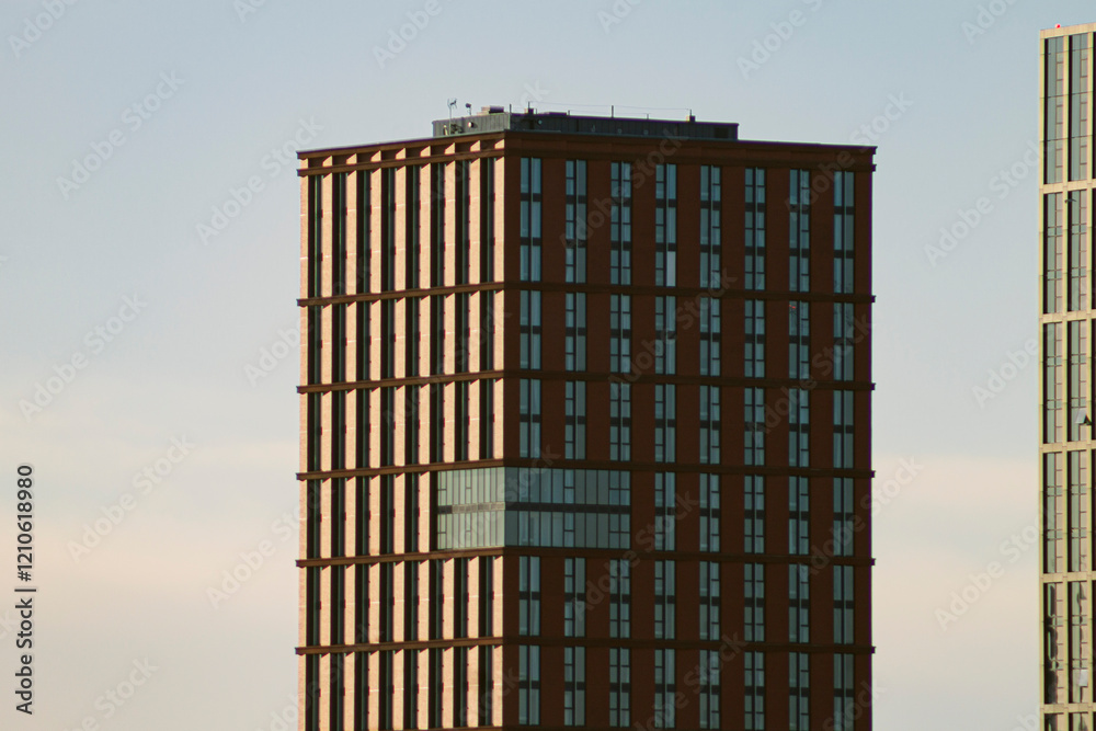 Manchester, United Kingdom, 2024:View of tall, modern buildings in the city centre, full of windows reflecting the sun in a cold afternoon with blue and clear sky. Picture has an orange and warm feel. Manchester, United Kingdom, 2024:View of tall, modern buildings in the city centre, full of windows reflecting the sun in a cold afternoon with blue and clear sky. Picture has an orange and warm feel.