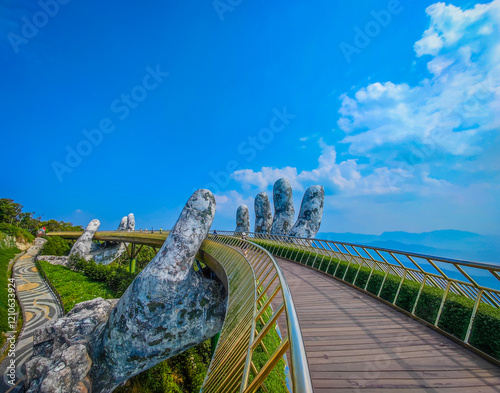 Empty Golden Bridge in Ba Na hills, Da Nang, Vietnam on a sunny day. Lifted by two giant concrete hands. Iconic world famous bridge in the mountains