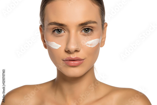 Beautiful youn.g woman posing with a cosmetic product on her face photo