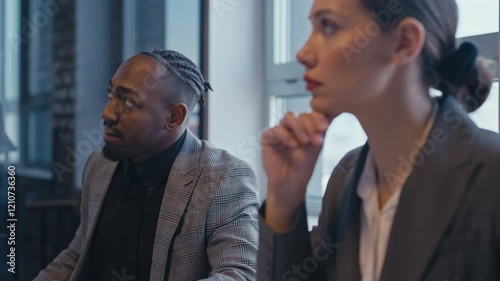 Two professionals attentively listen during a business meeting, showing active engagement and understanding. Concept of teamwork, communication, and corporate collaboration