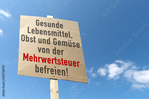 Forderung auf Kartonschild; Gesunde Lebensmittel,Obst und Gemüse von der Mehrwertsteuer befreien! photo