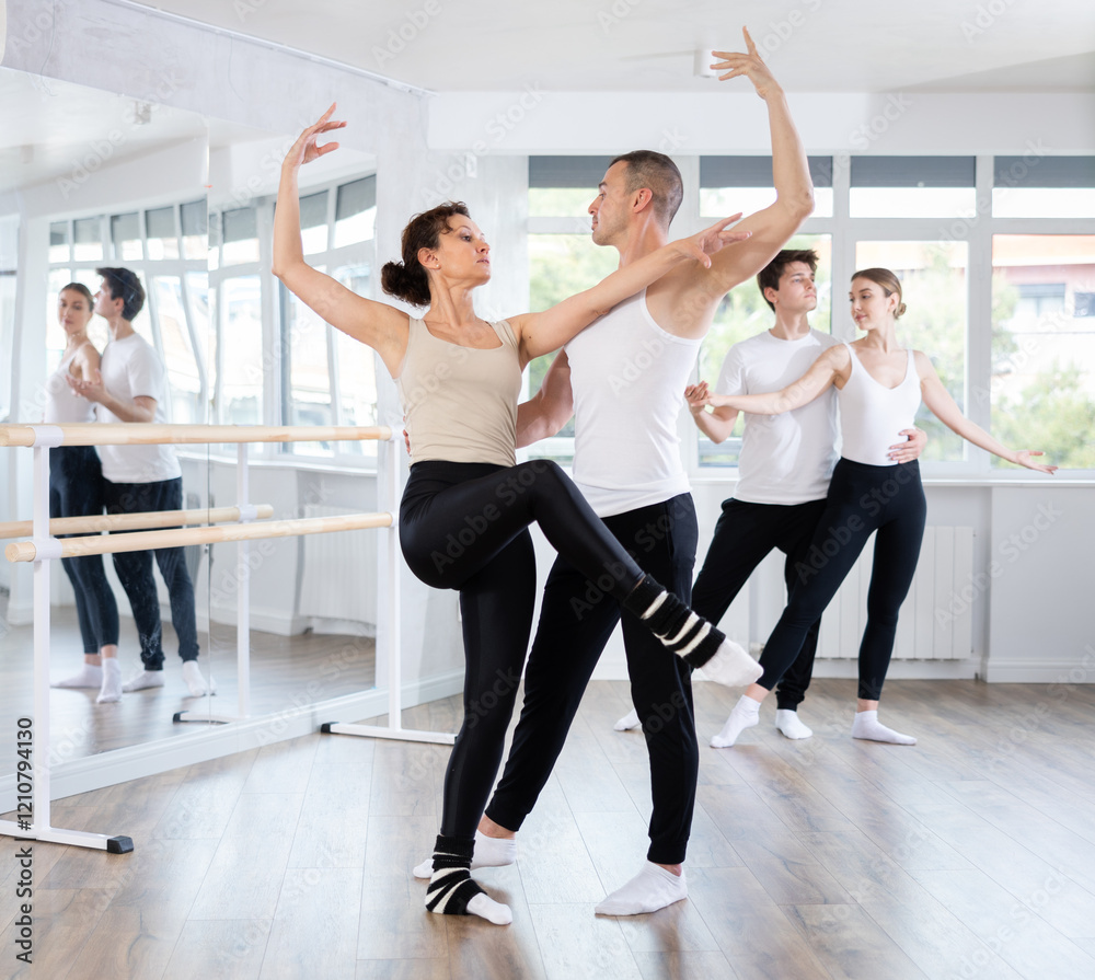 Young man and adult woman dancers rehearsing pair ballet in studio Young man and adult woman dancers rehearsing pair ballet in studio