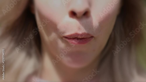 Young caucasian Woman with blond hair Eating Organic Wild Strawberries at sunny day. Unrecognisable Happy female person eats red ripe forest berries and smiles. Healthy eating and lifestyle concept. 