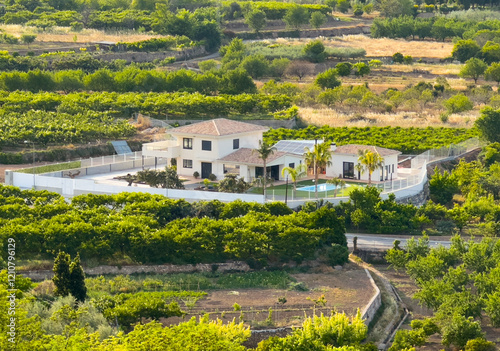 Spanish villa, aerial view. House in rural. Countryside with village houses near farm field. Rural landscape. Villa with garden. House in olive farm field. House roof in countryside with orange.