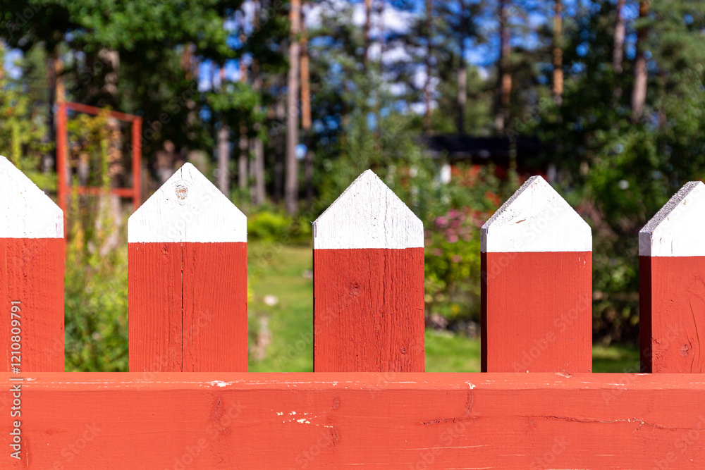 Fototapeta premium Red and white fence in a garden