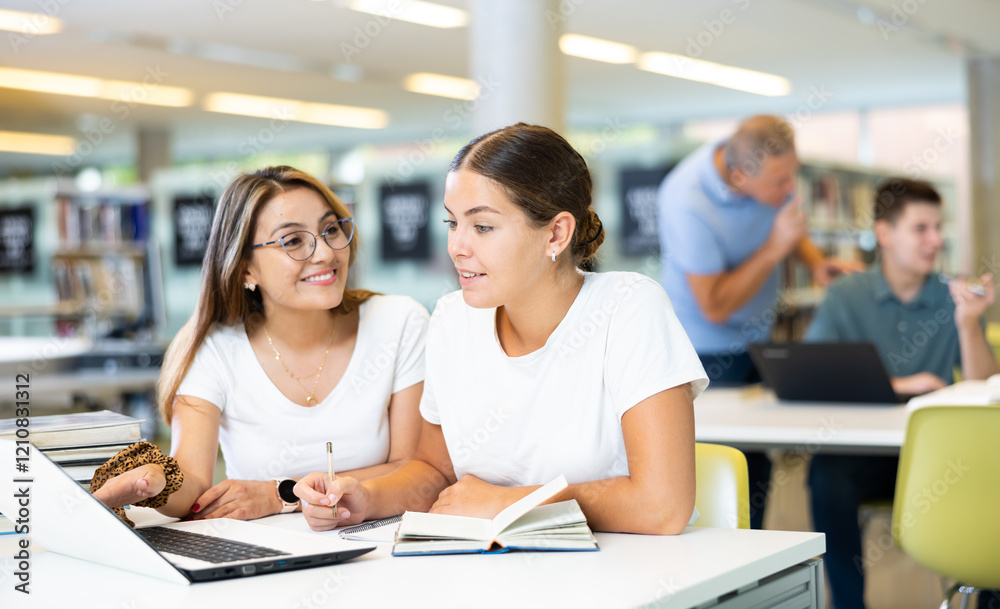 Young female students studying together compared to a noisy male in the background Young female students studying together compared to a noisy male in the background