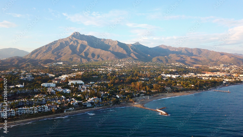 Obraz premium aerial view of the Playa de Nagüeles beach in front of the famous Pico de la Concha mountain, the landmark of Marbella in beautiful evening light, Costa del Sol, Spain