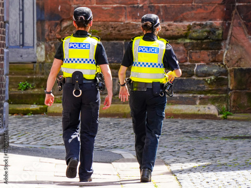 Policewomen walk the street in United Kingdom. photo