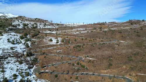 Drone Aerial View of Serpentine Road Through Snowy Hills