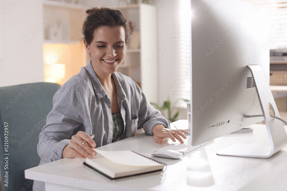 Happy woman working with computer at desk indoors. Home office Happy woman working with computer at desk indoors. Home office