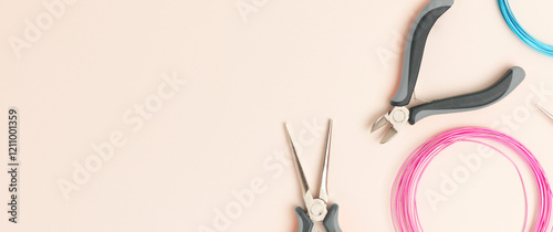 Banner with aluminum wire and tools for jewelry making on a beige background.