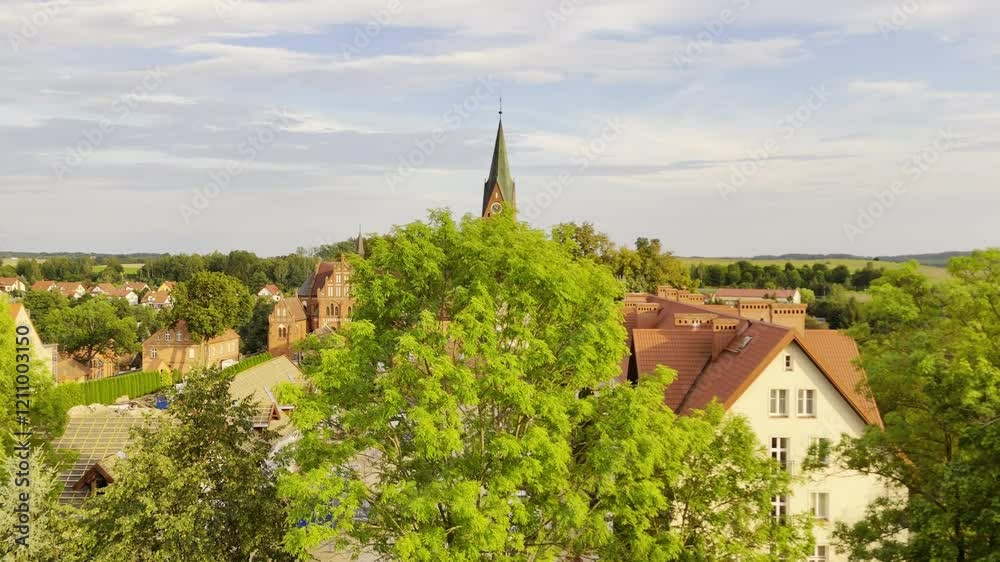 Aerial view of a historic church and picturesque village in Poland surrounded by green countryside Aerial view of a historic church and picturesque village in Poland surrounded by green countryside