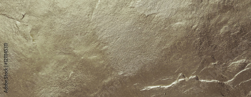 Metallic gold background with a textured, rough surface. The gold background adds a luxurious, elegant feel with its shimmering texture. Textured stone background vector. Gold background.