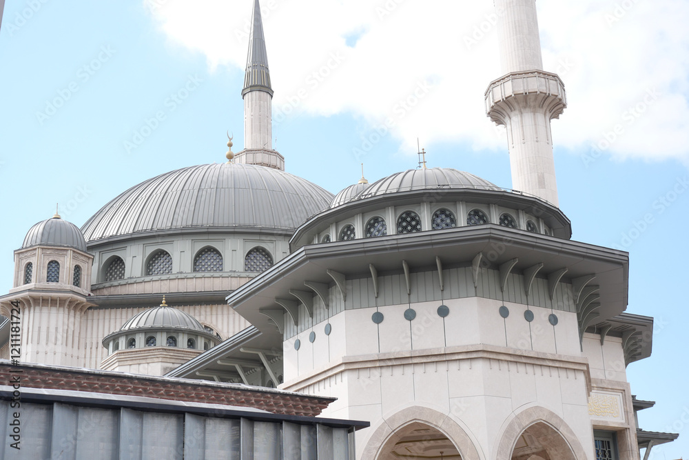 Fototapeta premium The Architectural Beauty of a Contemporary Mosque Set Against a Clear Blue Sky