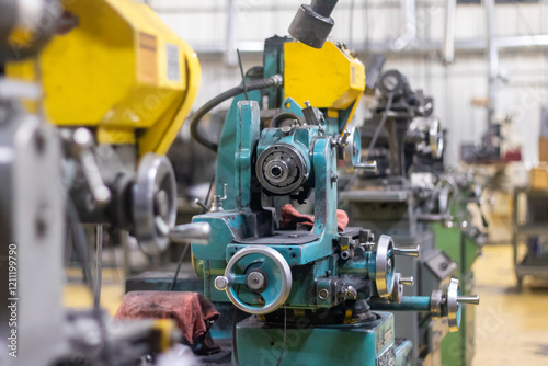 A big green and yellow industrial cutting machine in a warehouse.