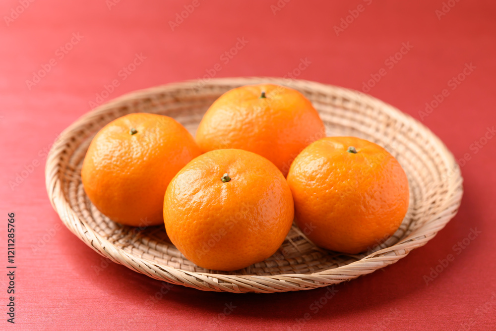Mandarin tangerine orange fruit in basket on red background, Lucky food in Lunar New Year or Chinese New Year Mandarin tangerine orange fruit in basket on red background, Lucky food in Lunar New Year or Chinese New Year