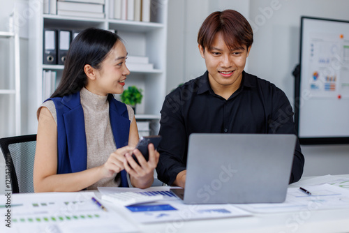 Entrepreneur Asian businessman and businesswoman discussing new business project in tablet in modern Meeting In Modern Office, Asian business casual concept.
