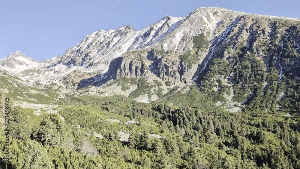 Ski lift in the middle of forest against mountain, surrounded by trees with clear sky above, offering a scenic view of the snowy landscape and natural surroundings. Ski lift in the middle of forest against mountain, surrounded by trees with clear sky above, offering a scenic view of the snowy landscape and natural surroundings.