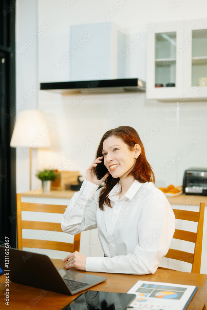 Woman using laptop while sitting at home. Young woman sitting in kitchen and working Woman using laptop while sitting at home. Young woman sitting in kitchen and working