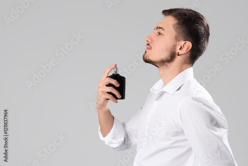 Handsome man applying perfu...