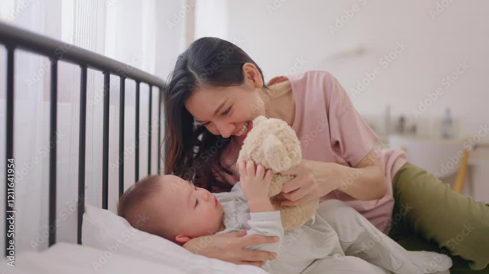Asian single mother lovingly cares for and raises her baby boy at home. 