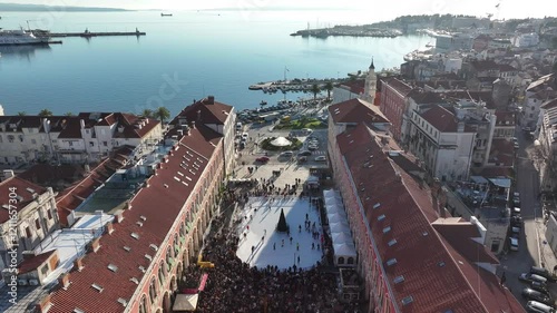 A bustling daytime view of Prokurative Square in Split during New Year’s Eve, filled with crowds enjoying the festive decorations and lively holiday atmosphere. photo