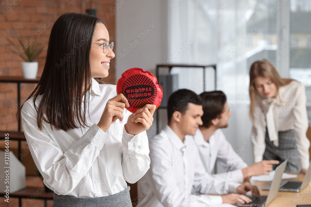 Businesswoman with whoopee cushion in office. April Fools' Day celebration Businesswoman with whoopee cushion in office. April Fools' Day celebration